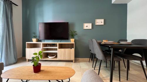 a living room with a tv and a table with chairs at Theseus Retreat 10 min walk from the Acropolis in Athens