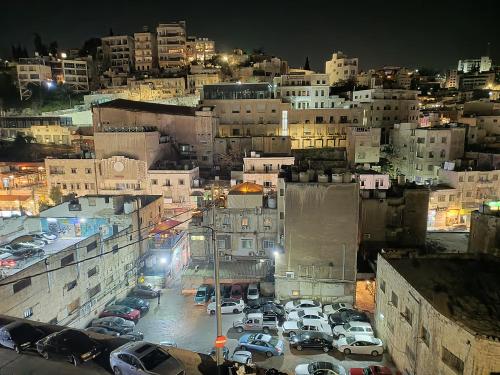 a city at night with cars parked in a parking lot at Gallery Hotel in Amman