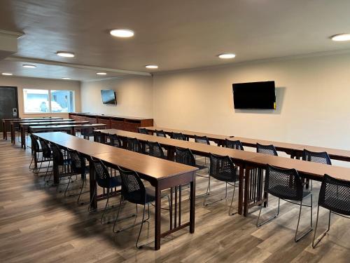 aula con mesas y sillas y TV de pantalla plana en Days Inn and Suites by Wyndham Port Huron, en Port Huron