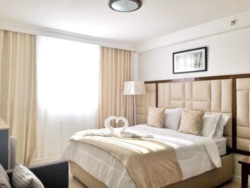a bedroom with a large bed with a large window at Attractive studio with Luxury bed Good for 1-4pax High speed WiFi with Netflix Free Pool & Parking in Suba