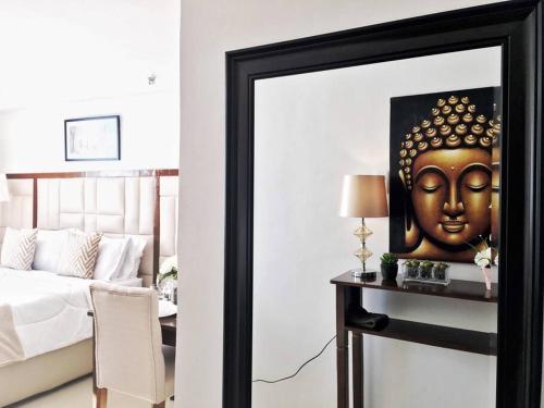 a mirror in a bedroom with a picture of a head at Attractive studio with Luxury bed Good for 1-4pax High speed WiFi with Netflix Free Pool & Parking in Suba