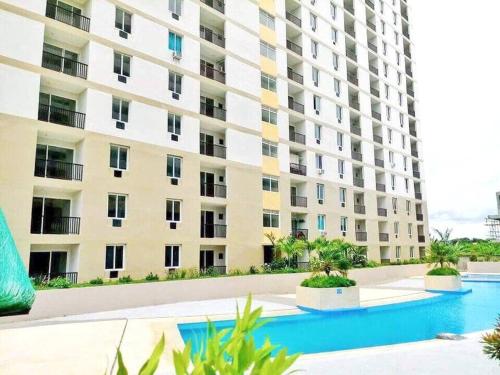 an apartment building with a swimming pool in front of it at Attractive studio with Luxury bed Good for 1-4pax High speed WiFi with Netflix Free Pool & Parking in Suba