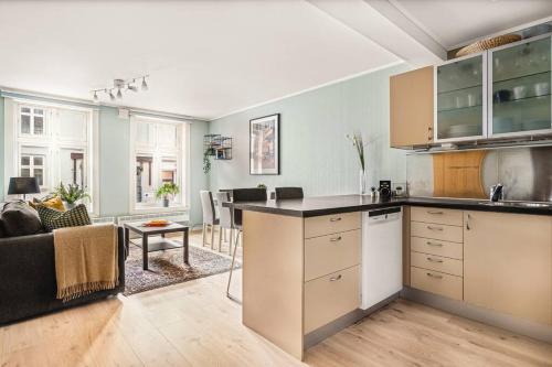 een open keuken en een woonkamer met een bank bij Dinbnb Apartments I Charming 3-Bedroom in the Heart of the City in Bergen