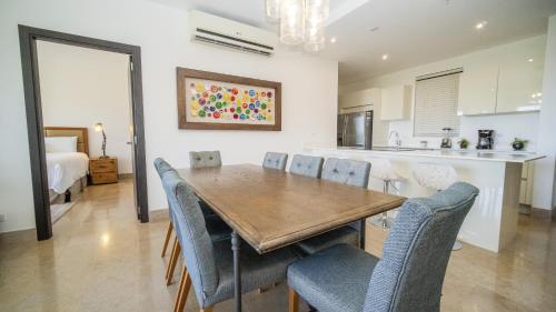a kitchen and dining room with a wooden table and chairs at Roble Sabana 105 Luxury Apartment - Reserva Conchal in Playa Conchal
