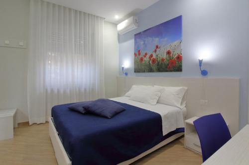 a bedroom with a bed with a painting on the wall at b&b Rita, nel cuore del Salento in Cavallino di Lecce