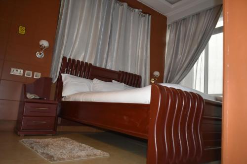 a bedroom with a large bed and a window at BWAMI DUBAI HOTEL KASULU 