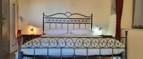 a bedroom with a black bed with white pillows at Apartment Nonna Delia in Guardea