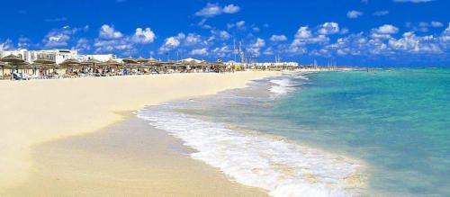 a beach with a group of umbrellas and the ocean at Zenon Djerba in Midoun