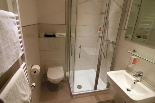 a bathroom with a shower and a toilet and a sink at Hotel Klasen in Cochem