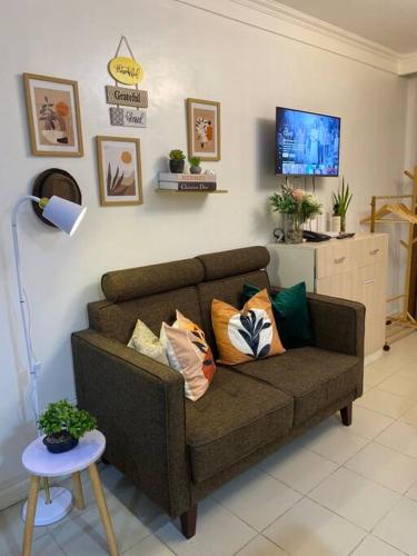 a living room with a couch with pillows on it at Minimalist studio with Luxury bed Good for 1-4pax High speed WiFi with Netflix Free Pool & Parking in Suba