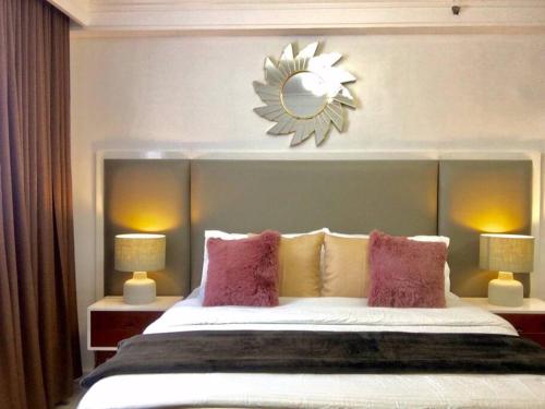 a bedroom with a bed with a mirror above it at Minimalist studio with Luxury bed Good for 1-4pax High speed WiFi with Netflix Free Pool & Parking in Suba