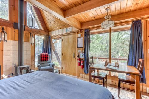 a bedroom in a log cabin with a bed and a desk at Chalet Shangri-La in Welches