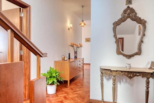 Casa do Valentim, a Home in Madeira في بونتا دو سول: ممر مع طاولة تزيين ومرآة