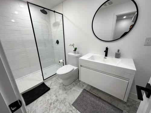 y baño con aseo, lavabo y espejo. en New & Renovated Spacious 2BR Apt in Thornhill en Vaughan