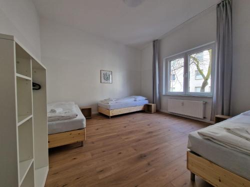 een kamer met 2 bedden en een raam bij RAJ Living - 2 , 3 and 4 Room Apartments - 25 Min Messe DUS in Duisburg