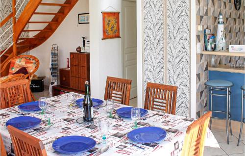 a table with blue plates and a bottle of wine at 3 Bedroom Cozy Home In Lamballe-Armor in Planguenoual