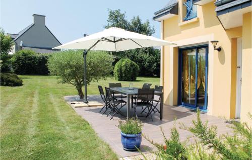 un patio avec une table et un parasol dans l'établissement 3 Bedroom Cozy Home In Lamballe-Armor, à Planguenoual