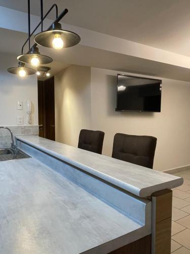 a kitchen with a blue counter top and chairs at Apartamento en Ecovivienda Fase 2 Tegucigalpa in Tegucigalpa