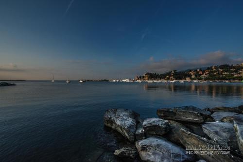a large body of water with rocks in the foreground at Hotel Italia e Lido Rapallo in Rapallo