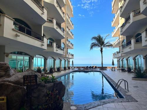 a swimming pool in front of a building at Depa frente a la playa by G P S rentas in Mazatlán
