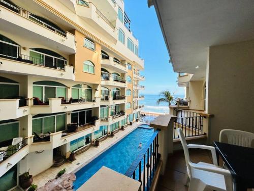 a view of a hotel with a swimming pool and the ocean at Depa frente a la playa by G P S rentas in Mazatlán