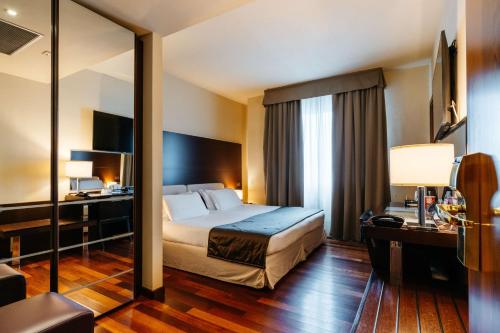 una camera d'albergo con letto e specchio di Best Western Hotel Tre Torri ad Altavilla Vicentina