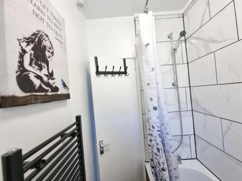 a bathroom with a shower and a sink and a toilet at The Headlam Apartment in London