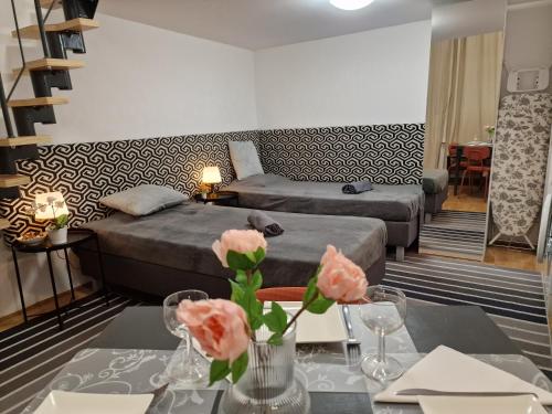 a hotel room with two beds and a table with flowers at Bercsényi apartments - close to the Gellért Thermal Bath in Budapest