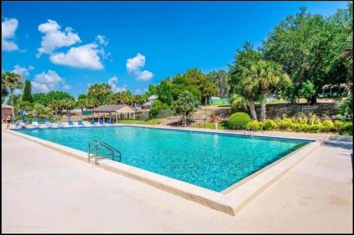 a large swimming pool with blue water in a resort at Beautiful cottage near Lake Louisa & mins from Disney, Vehicle Rental Available in Clermont