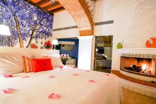 a bedroom with a white bed with a fireplace at Anticavilla Hotel Restaurante & Spa in Cuernavaca