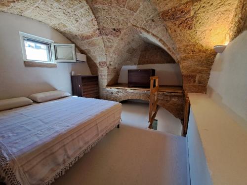 トリカーゼにあるCorte Giuggiolaの石壁のベッドルーム1室(ベッド1台付)