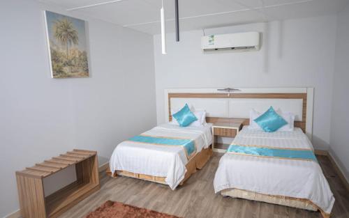 una camera con due letti e una panca di Yar Furnished Apartments a Jazan