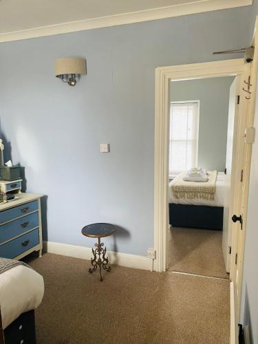 a bedroom with a mirror and a bed and a stool at Arosfa Harbourside Aberaeron in Aberaeron