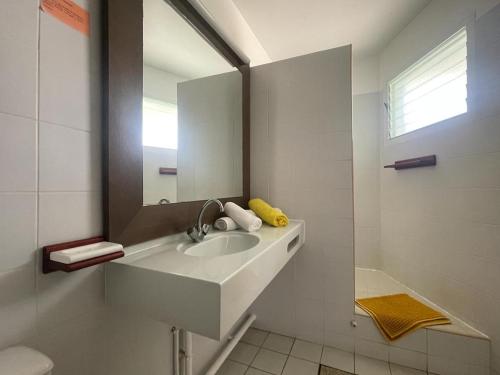 bagno bianco con lavandino e specchio di NIKOTOU - Manganao a Saint-François