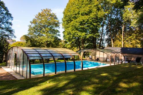 une serre et une piscine dans une cour dans l'établissement Château du Romerel - Baie de Somme, à Saint-Valery-sur-Somme