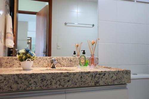 a bathroom counter with a sink and a mirror at Maceio Ferias apto com varanda vista mar in Maceió