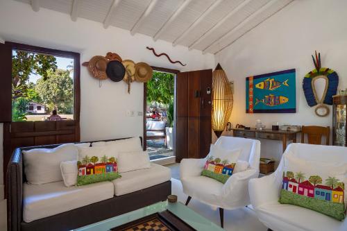 ein Wohnzimmer mit 2 Stühlen und einem Sofa in der Unterkunft Pousada Hospedaria do Quadrado in Trancoso