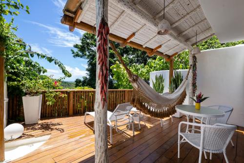 una terraza con hamaca, mesa y sillas en Pousada Hospedaria do Quadrado en Trancoso