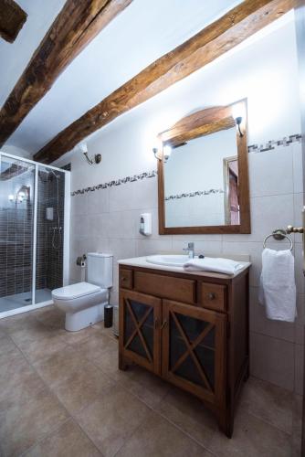 a bathroom with a sink and a toilet and a mirror at Masía Nicolás in Cella