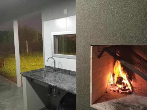 a kitchen with a fireplace and a sink and a stove at Descanso en Las Acequias in Roldán