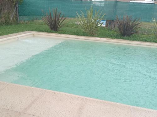 a swimming pool with blue water in a yard at Descanso en Las Acequias in Roldán