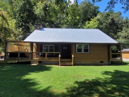 a small wooden house with a porch and a yard at Creekside Hideaway - Real Log Cabin w/Great Location in Pigeon Forge
