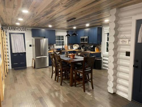 a kitchen with blue cabinets and a table and chairs at Creekside Hideaway - Real Log Cabin w/Great Location in Pigeon Forge