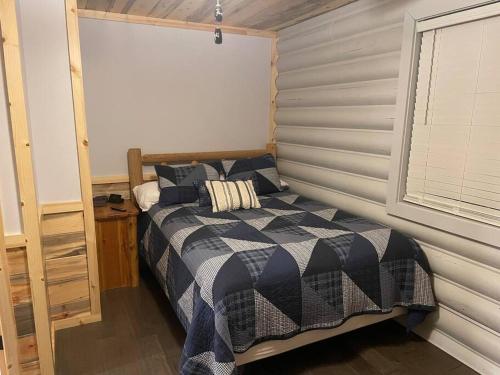 a bedroom with a bed and a window in it at Creekside Hideaway - Real Log Cabin w/Great Location in Pigeon Forge