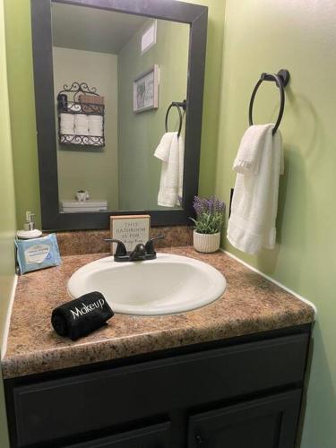 a bathroom with a sink and a mirror at Creekside Hideaway - Real Log Cabin w/Great Location in Pigeon Forge