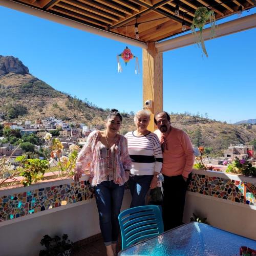 a group of three people standing on a balcony at Hotel Spa Maggic Home Panorámica in Guanajuato