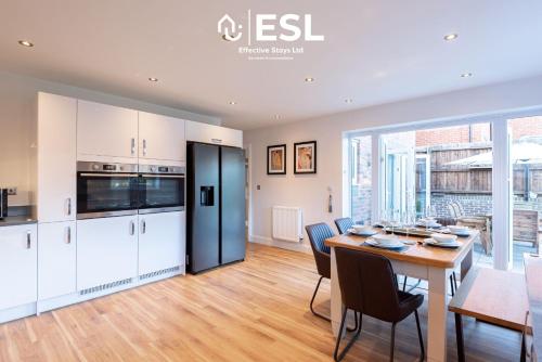 a kitchen and dining room with a table and chairs at Large Modern 4 Bedroom House in Uttoxeter, Near Alton Towers, Great for Families in Uttoxeter