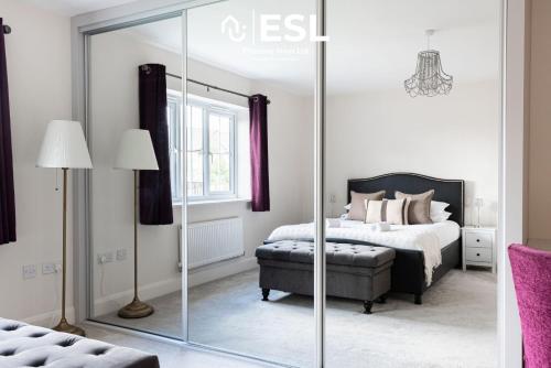 a bedroom with a bed and a large mirror at Large Modern 4 Bedroom House in Uttoxeter, Near Alton Towers, Great for Families in Uttoxeter