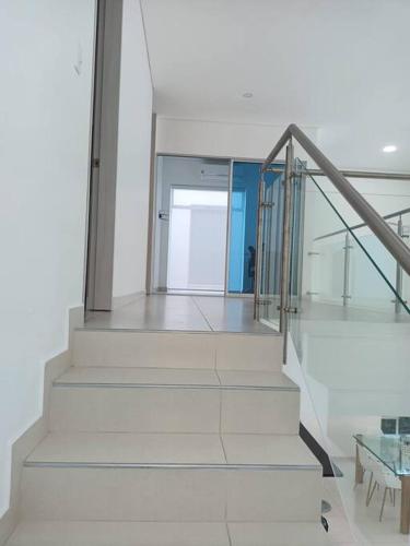 a white staircase in a room with a table at Condo Apulo - Hermosa casa - Jacuzzi y Piscina privados - WiFi in Apulo