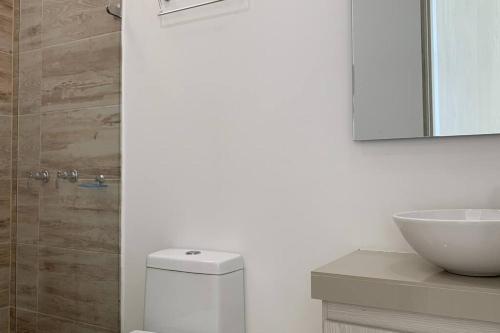 ein Badezimmer mit einem WC, einem Waschbecken und einem Spiegel in der Unterkunft Condo Apulo - Hermosa casa - Jacuzzi y Piscina privados - WiFi in Apulo